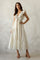 woman wearing a cream floral maxi dress with ruffled sleeves and a tie-front detail