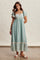 woman wearing a teal floral maxi dress with ruffled sleeves and lace trim, styled with sandals and layered jewelry