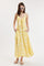 woman wearing a yellow floral maxi dress with adjustable straps and a bow detail at the waist