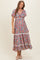 woman wearing a floral print maternity dress with short flutter sleeves and a tie front, showcasing a baby bump