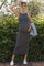 woman wearing a black and white striped ribbed maternity dress and holding her baby bump outdoors
