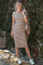 woman wearing a brown and cream striped fitted dress with a scoop neckline and styled with white sneakers