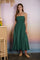 woman wearing a green smocked waist maxi dress with thin straps and a flowing skirt