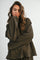 woman wearing an oversized brown striped long sleeve top with a relaxed fit and rolled cuffs