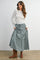 woman wearing a white lace long sleeve top and a green and white gingham tiered maxi skirt with brown knee-high boots