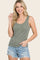 woman wearing a green and white striped tank top with button details and light denim shorts