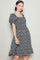 woman wearing a black floral smocked dress with puff sleeves and a ruffled hem