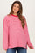 woman wearing a pink and red striped oversized maternity top with long sleeves and a relaxed fit