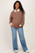woman wearing a brown and white striped maternity polo shirt with a baby bump, paired with light blue flared jeans