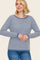 woman wearing a blue and white striped long sleeve sweater with a relaxed fit and contrasting neckline and cuffs
