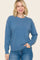woman wearing a soft blue long sleeve sweater with a relaxed fit and crew neckline, paired with light wash jeans
