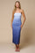 woman wearing a light blue spaghetti strap midi dress with side slits and a fitted silhouette