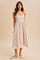 woman wearing a pastel pink floral midi sundress with thin straps and pockets