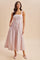 woman wearing a light pink floral maxi dress with a fitted bodice and pockets, styled with ballet flats