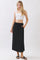 woman wearing a white crop top and a black maxi skirt with an elastic waistband and drawstring detail