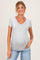woman wearing a light gray short sleeve maternity top with a v-neck and a visible baby bump