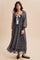 woman wearing a black and white polka dot maxi dress with puff sleeves and a ribbon tie at the neck