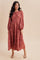 woman wearing a rust floral long sleeve midi dress with puff sleeves and a flowy skirt