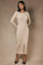 woman wearing a beige ribbed midi dress with buttons and a front slit, posing against a textured background