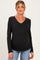 woman wearing a black long sleeve maternity top with a v-neck and ruching on the sides, showing her baby bump