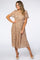 woman wearing a beige floral pleated midi dress with flutter sleeves and tan heels