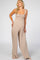 woman wearing a light brown maternity jumpsuit with a smocked bodice and wide legs, showcasing her baby bump