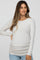 woman wearing a light gray long sleeve maternity top with side ruching and a visible baby bump