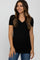 woman wearing a black short sleeve maternity top with a v-neck and ruched sides, smiling with a baby bump visible