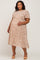 woman wearing a floral printed maternity plus dress with short sleeves and a visible baby bump