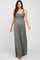 woman wearing a green maternity jumpsuit with a smocked bodice and wide legs, showcasing her baby bump