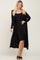 woman wearing a black ribbed tank dress with a long black cardigan over it and black slide sandals