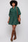 woman wearing a green corduroy shirt dress with puffed sleeves and knee-high brown boots