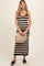 woman wearing a black and white striped maternity maxi dress and holding a woven bag with a baby bump visible