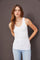 woman wearing a white ribbed tank top and light blue high-waisted jeans