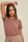 woman wearing a mauve short sleeve t-shirt with a relaxed fit and subtle ribbed texture