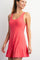woman wearing a pink sleeveless skater dress with a flared skirt and a scoop neckline