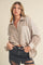 woman wearing a beige and cream striped button-up shirt with rolled sleeves and distressed black denim shorts