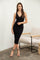 woman wearing a black ribbed midi dress with a v-neckline and decorative buttons