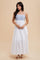 woman wearing a white maxi dress with blue embroidered detailing and thin straps