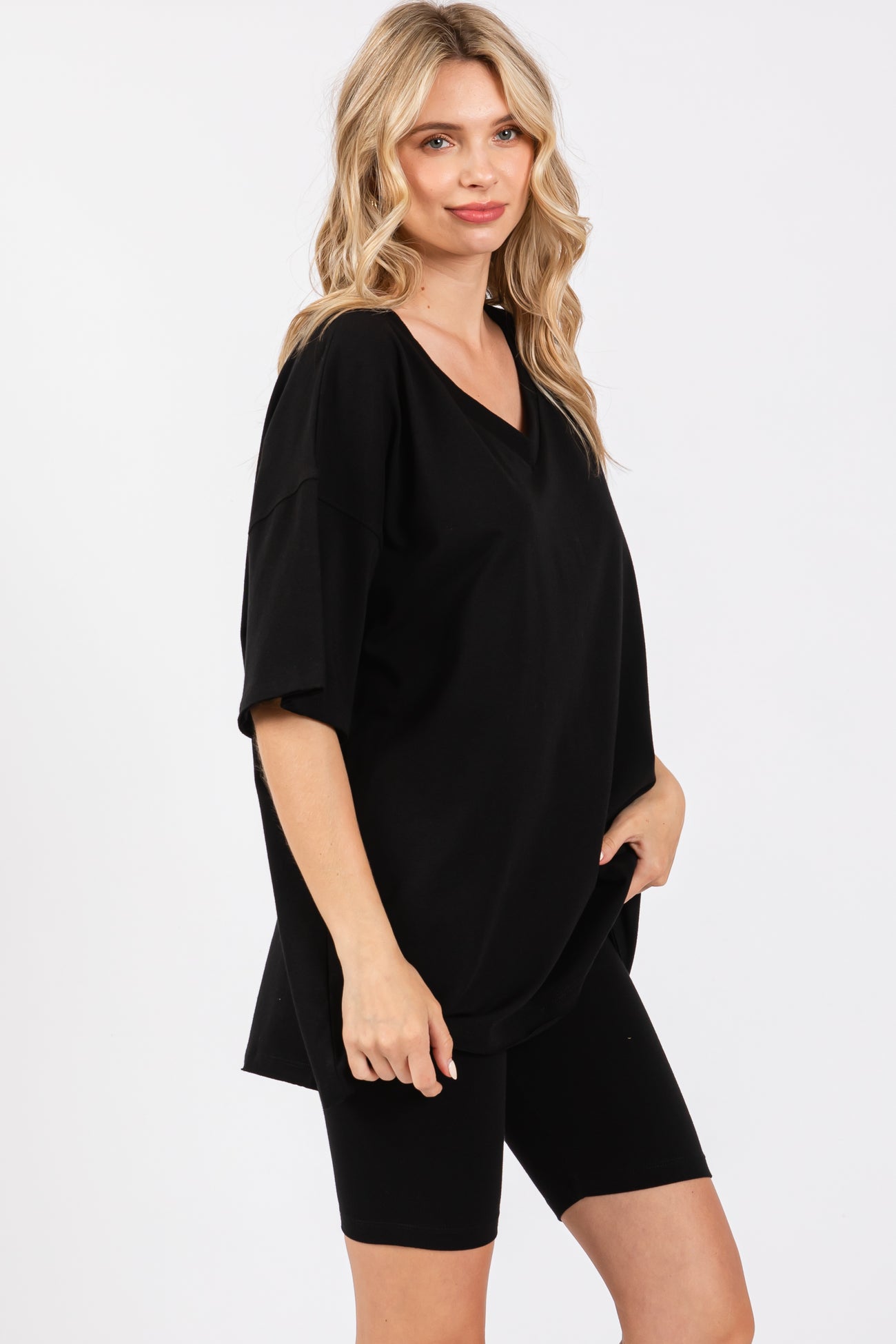woman wearing a black oversized v-neck t-shirt paired with black bike shorts