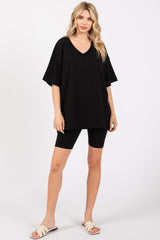 woman wearing an oversized black v-neck t-shirt with black biker shorts and sandals