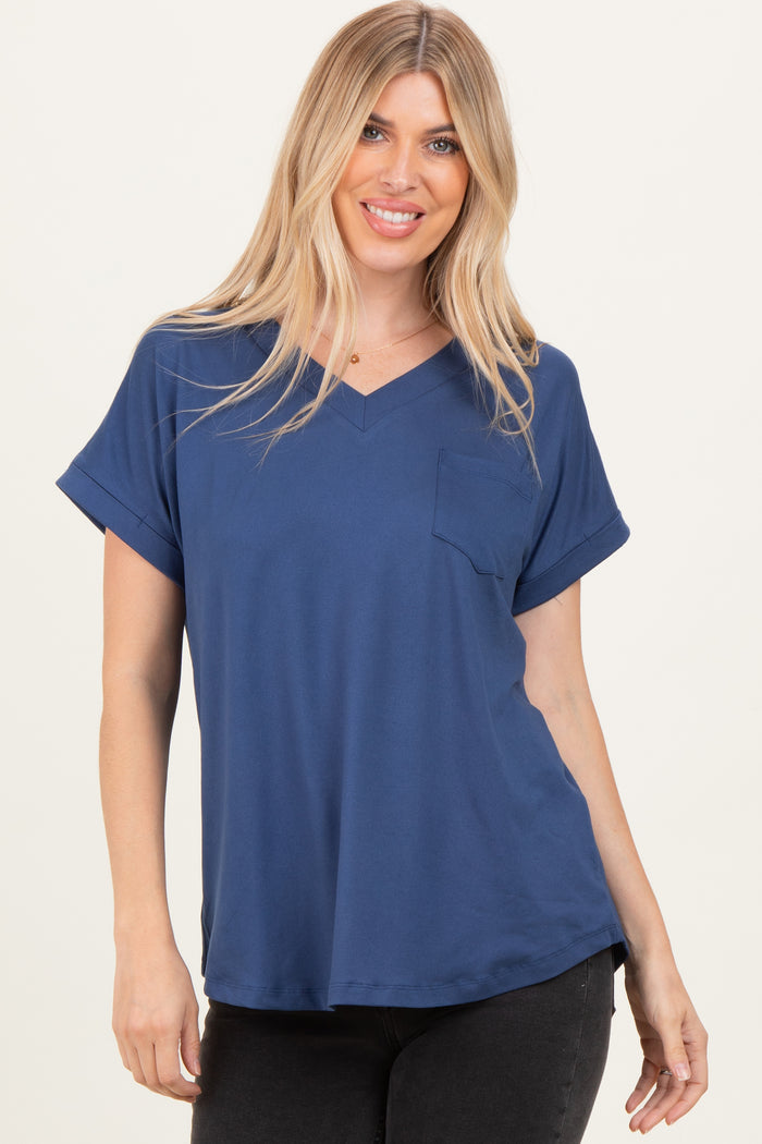 woman wearing a navy blue short sleeve v-neck top with a front pocket and rolled sleeves