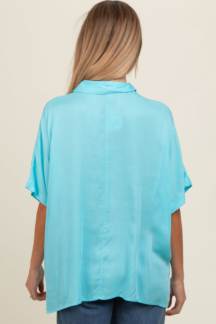 woman wearing a light blue short sleeve maternity blouse, shown from the back