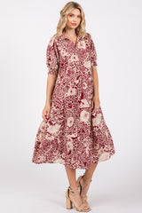 woman wearing a burgundy and cream floral print midi dress with puff sleeves and a button-up front
