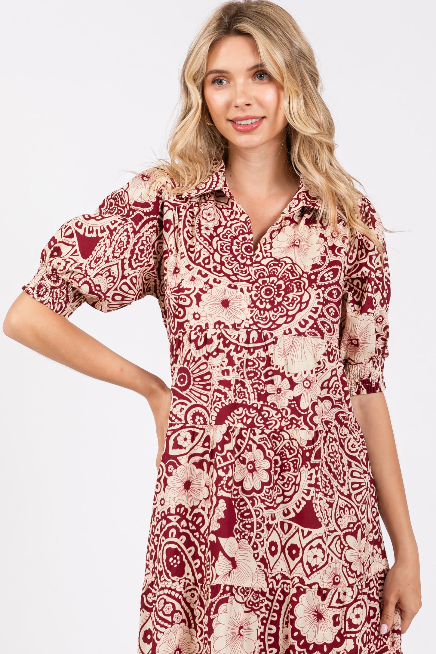 woman wearing a maroon and cream floral print shirt dress with short sleeves and a collared neckline