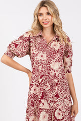 woman wearing a maroon and cream floral print shirt dress with short sleeves and a collared neckline