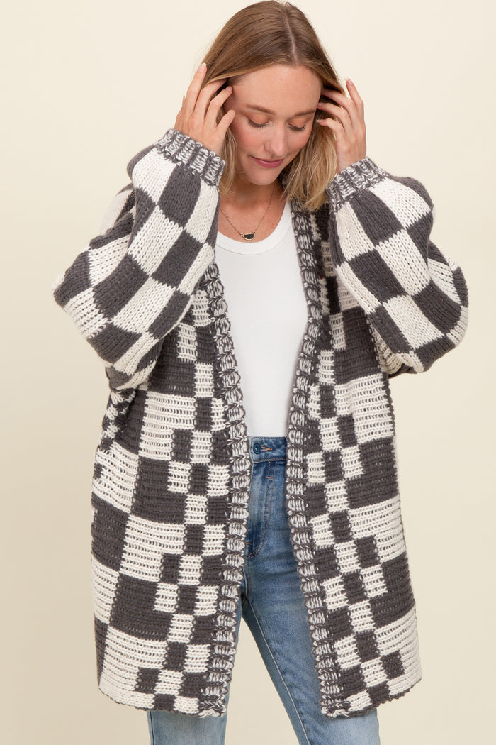 woman wearing a gray and white checkered oversized knitted cardigan over a white t-shirt and blue jeans