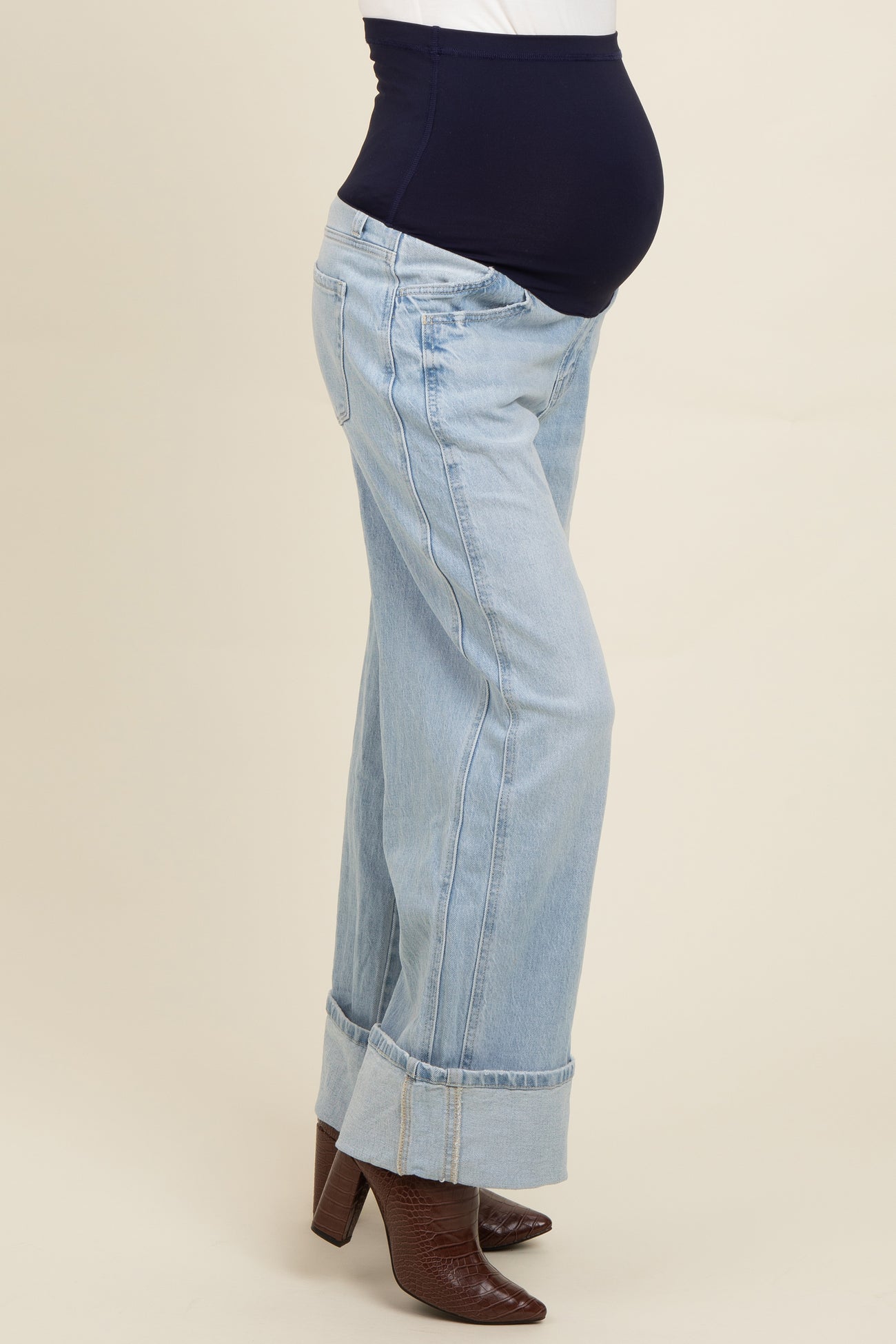woman wearing light blue maternity jeans with a stretchy black waistband and a visible baby bump