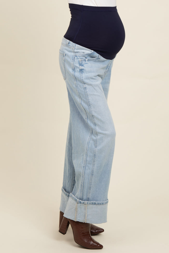 woman wearing light blue maternity jeans with a stretchy black waistband and a visible baby bump