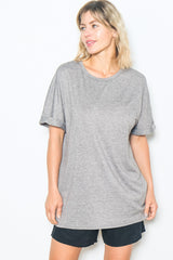 woman wearing a grey oversized t-shirt with rolled short sleeves and black shorts